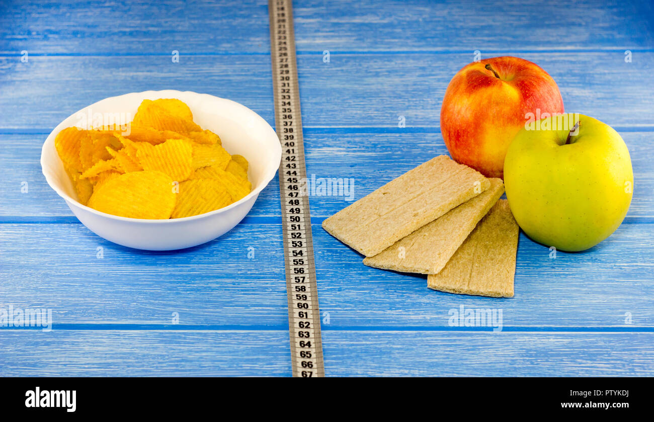 Chips apples breads centimeter tape on a blue wooden background Stock Photo