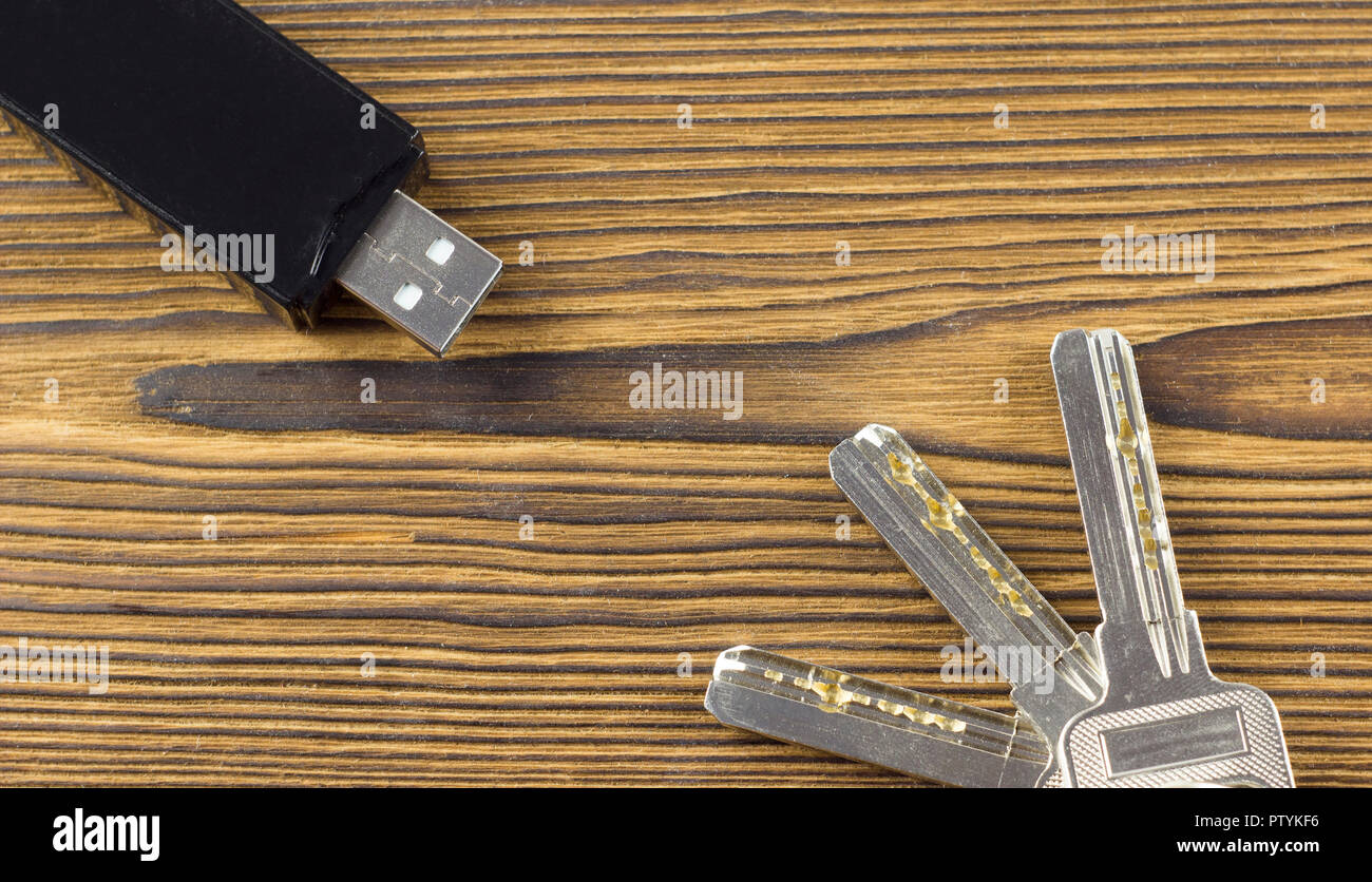 Black flash drive on a wooden background and keys Stock Photo