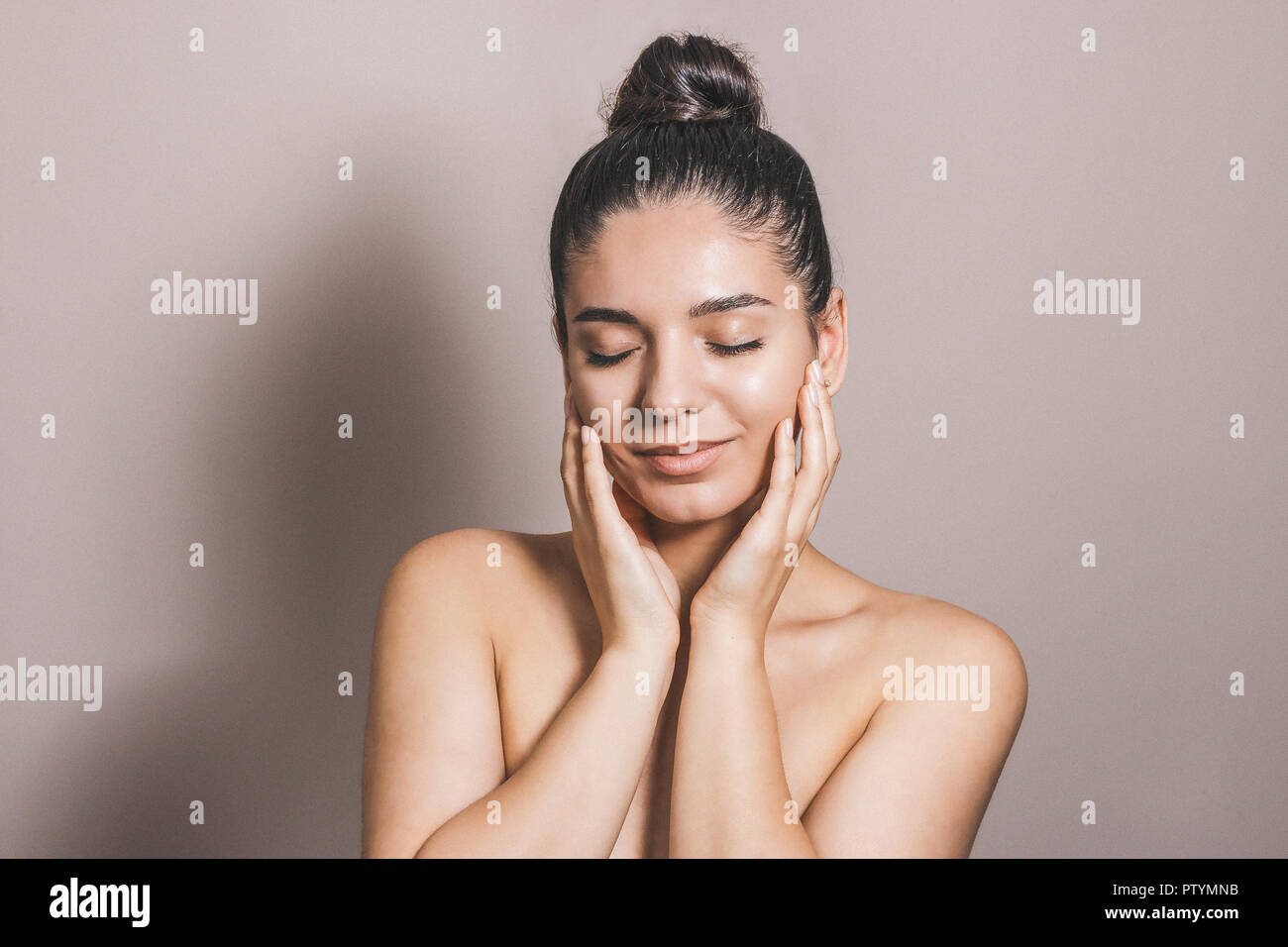 Beautiful woman with clean natural skin and eyes closed touching her ...