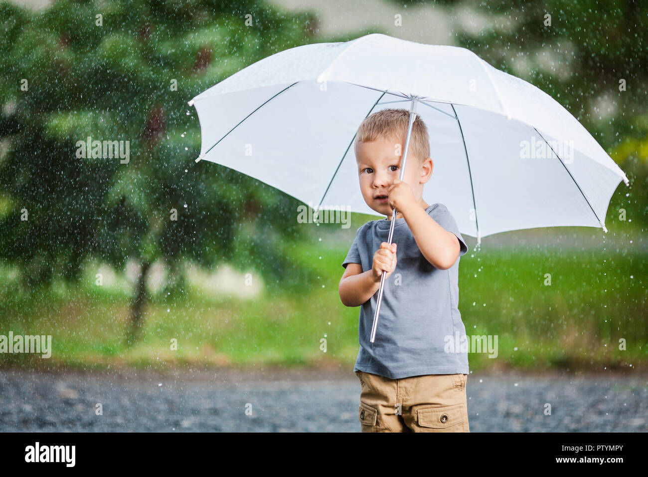 Child with umbrella and rain boots rain hi-res stock photography and ...