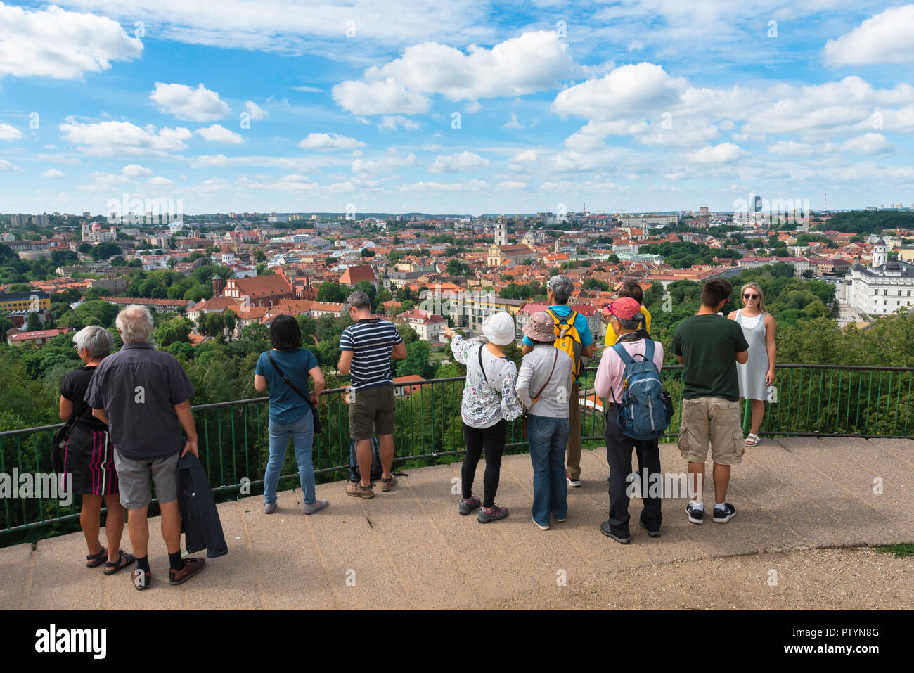 Tourism tourists Europe, on a summer day a group of tourists look down on the city of Vilnius from a viewing terrace on Three Crosses Hill, Lithuania. Stock Photo