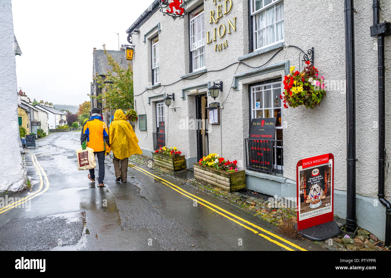 Tourists visiting the small town of Hawkshead in the lake district get caught out in a heavy rain shower Stock Photo