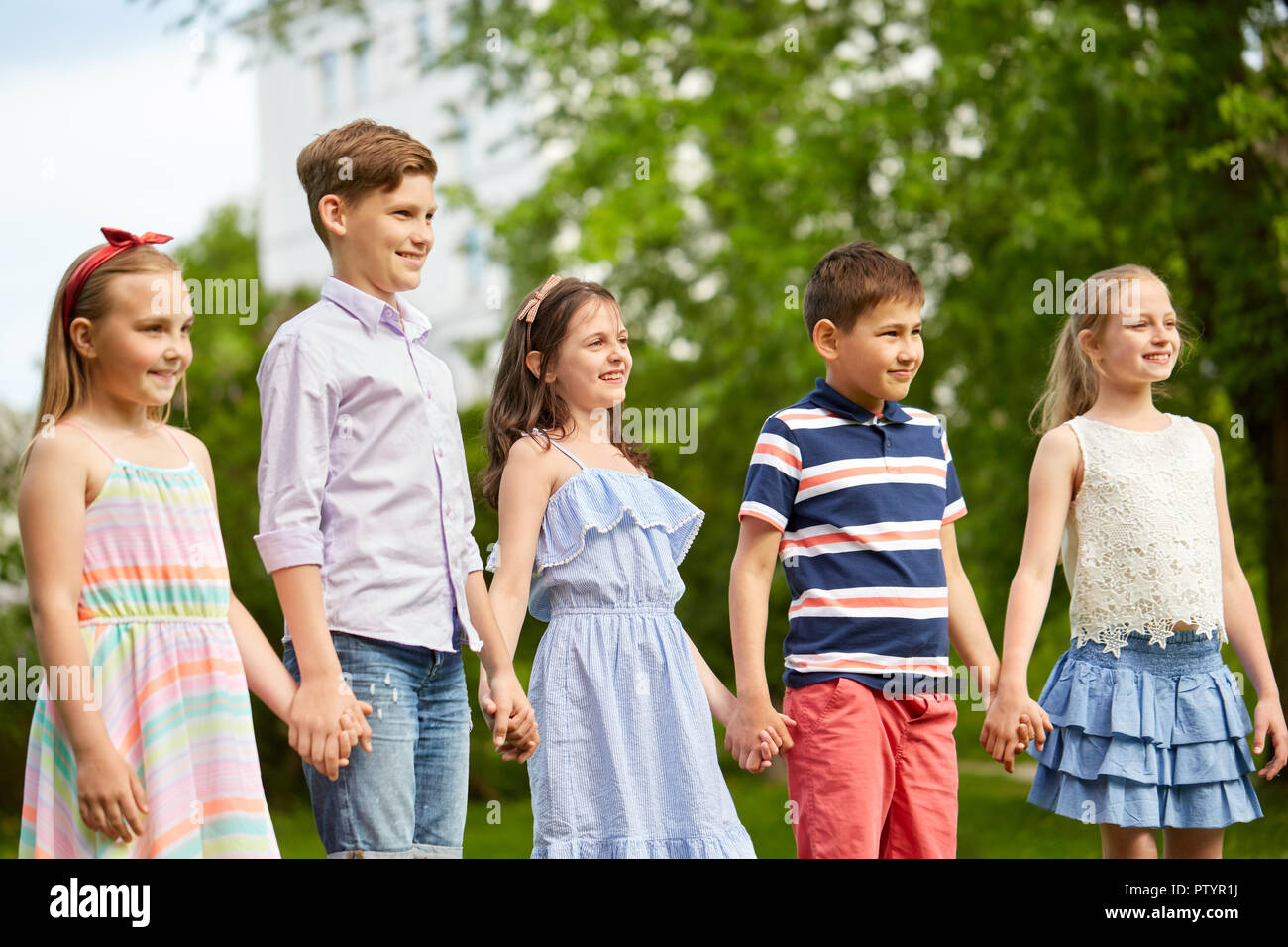 happy kids holding hands in summer park Stock Photo