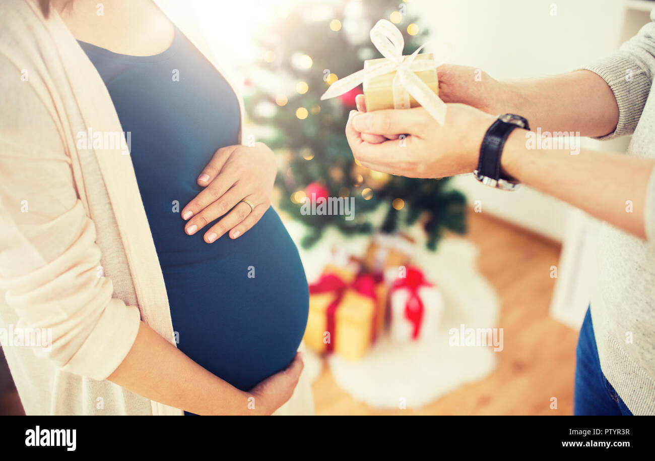 husband giving christmas present to pregnant wife Stock Photo - Alamy