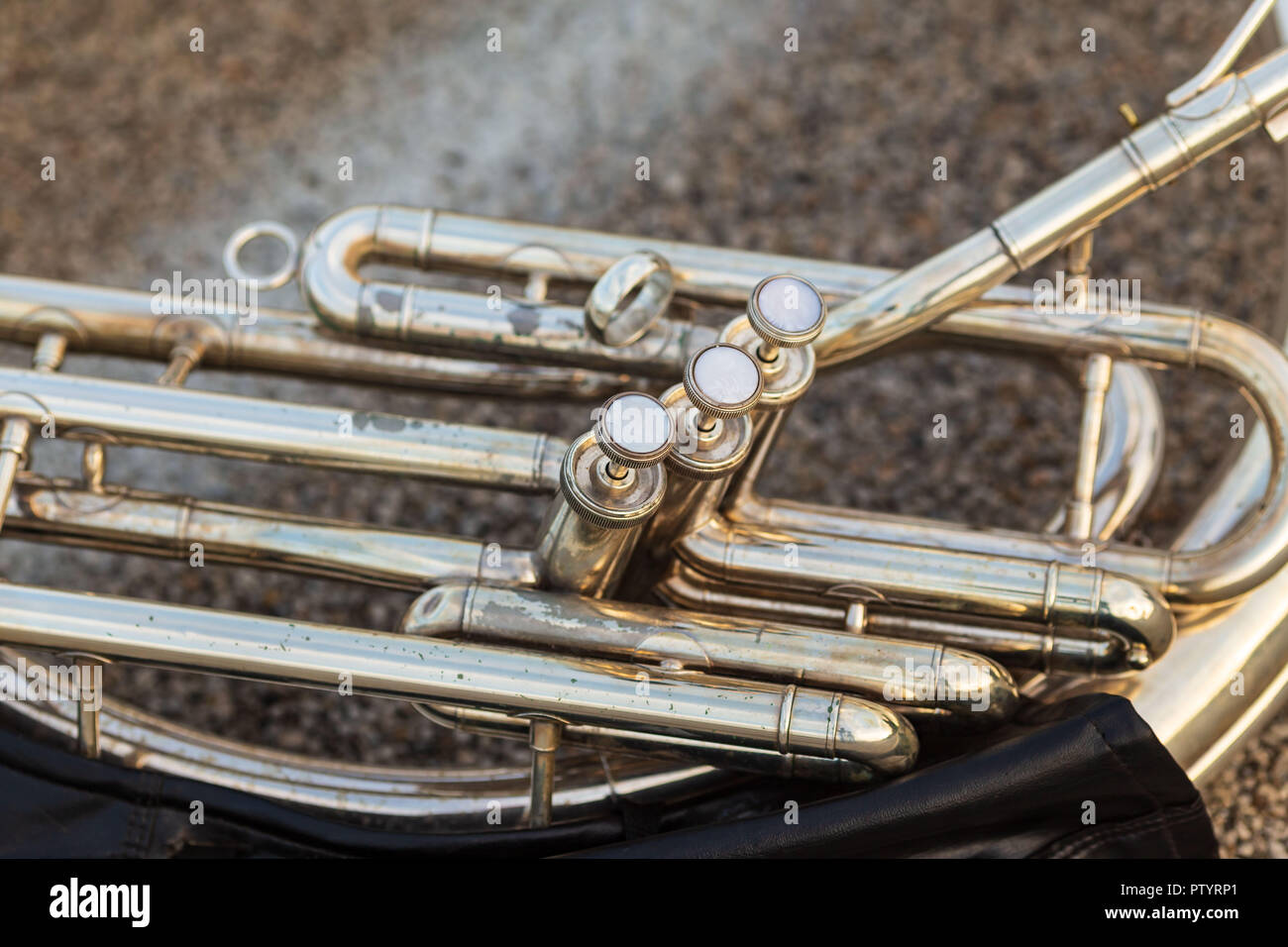 a close up of the keys of a sousaphone resting on the ground during a marching band rehearsal Stock Photo