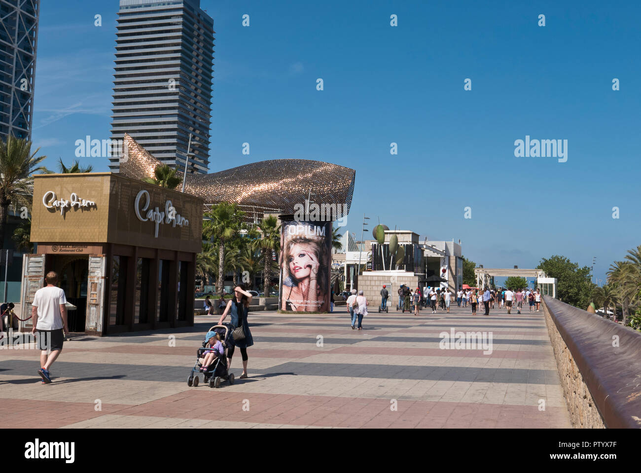 People walking along the promenade by the seafront in Barcelona, Spain Stock Photo