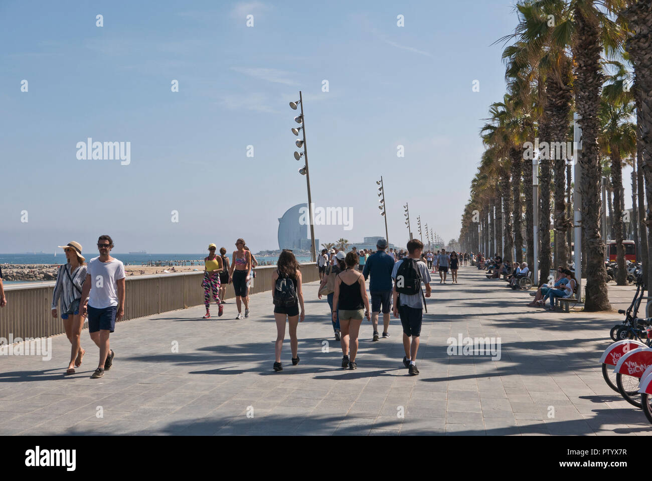 People walking along the promenade by the seafront in Barcelona, Spain Stock Photo