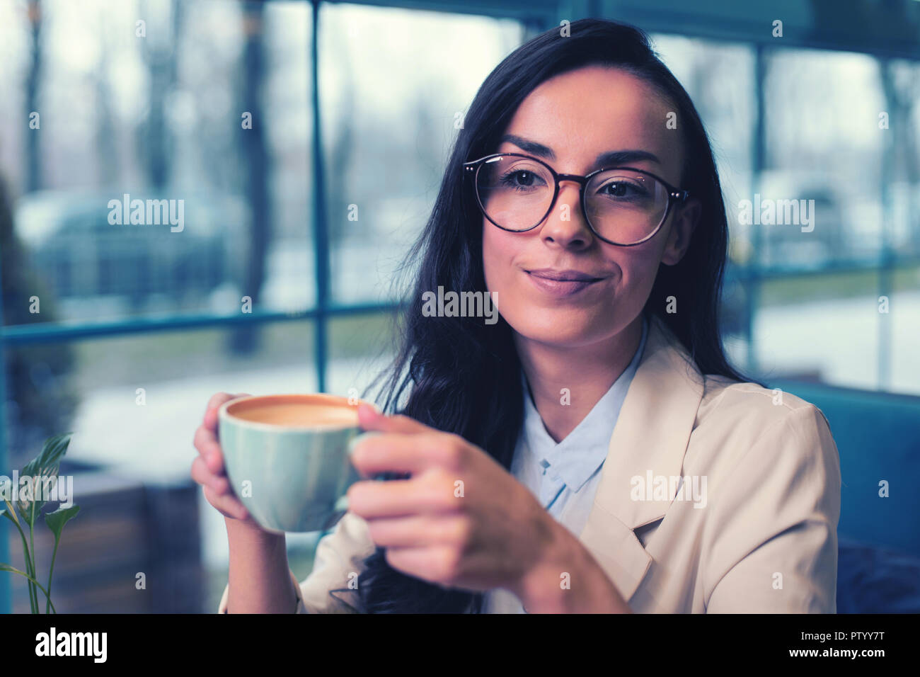 Cheerful young woman enjoying her morning coffee Stock Photo