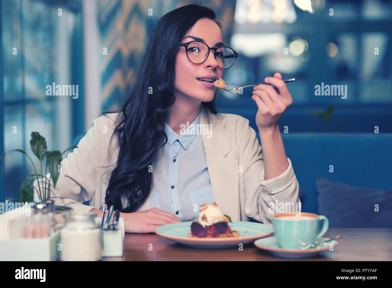 Positive delighted female person trying tasty cake Stock Photo