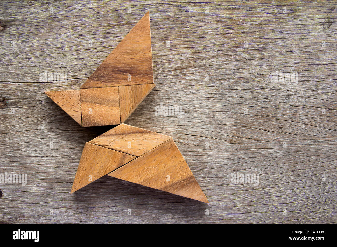 Wooden tangram puzzle in flying butterfly shape background Stock Photo