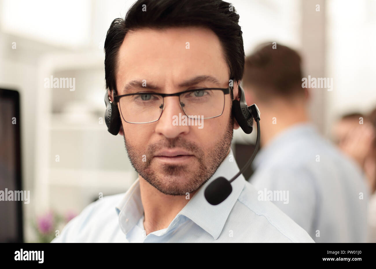 Group of business colleagues with headsets using computers at office desk Stock Photo