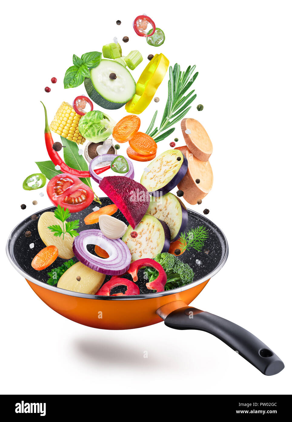 Flying fresh vegetables and spices over a pan. File contains clipping path. Flying motion effect. Stock Photo