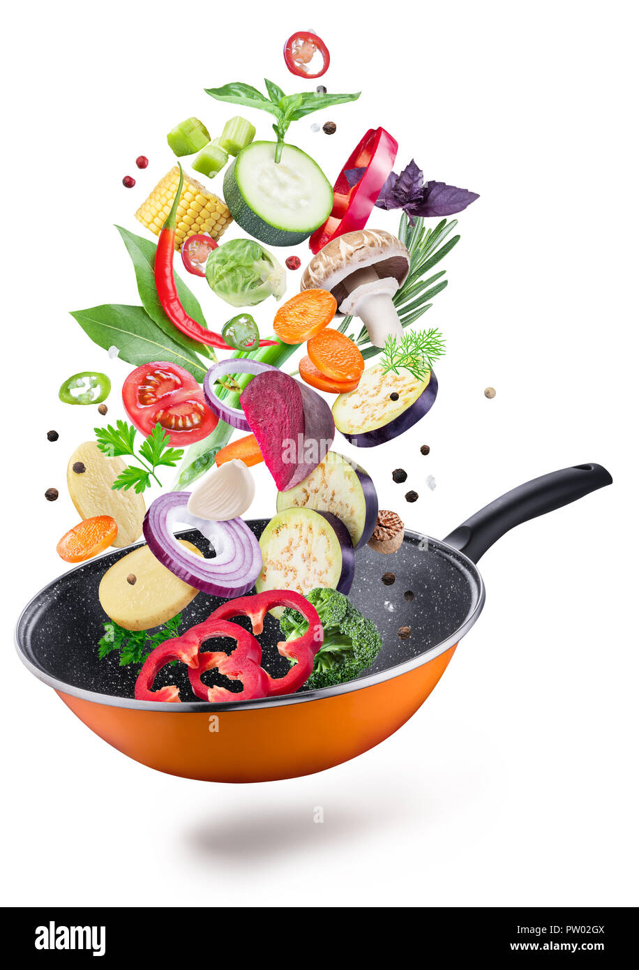 Flying fresh vegetables and spices over a pan. File contains clipping path. Flying motion effect. Stock Photo