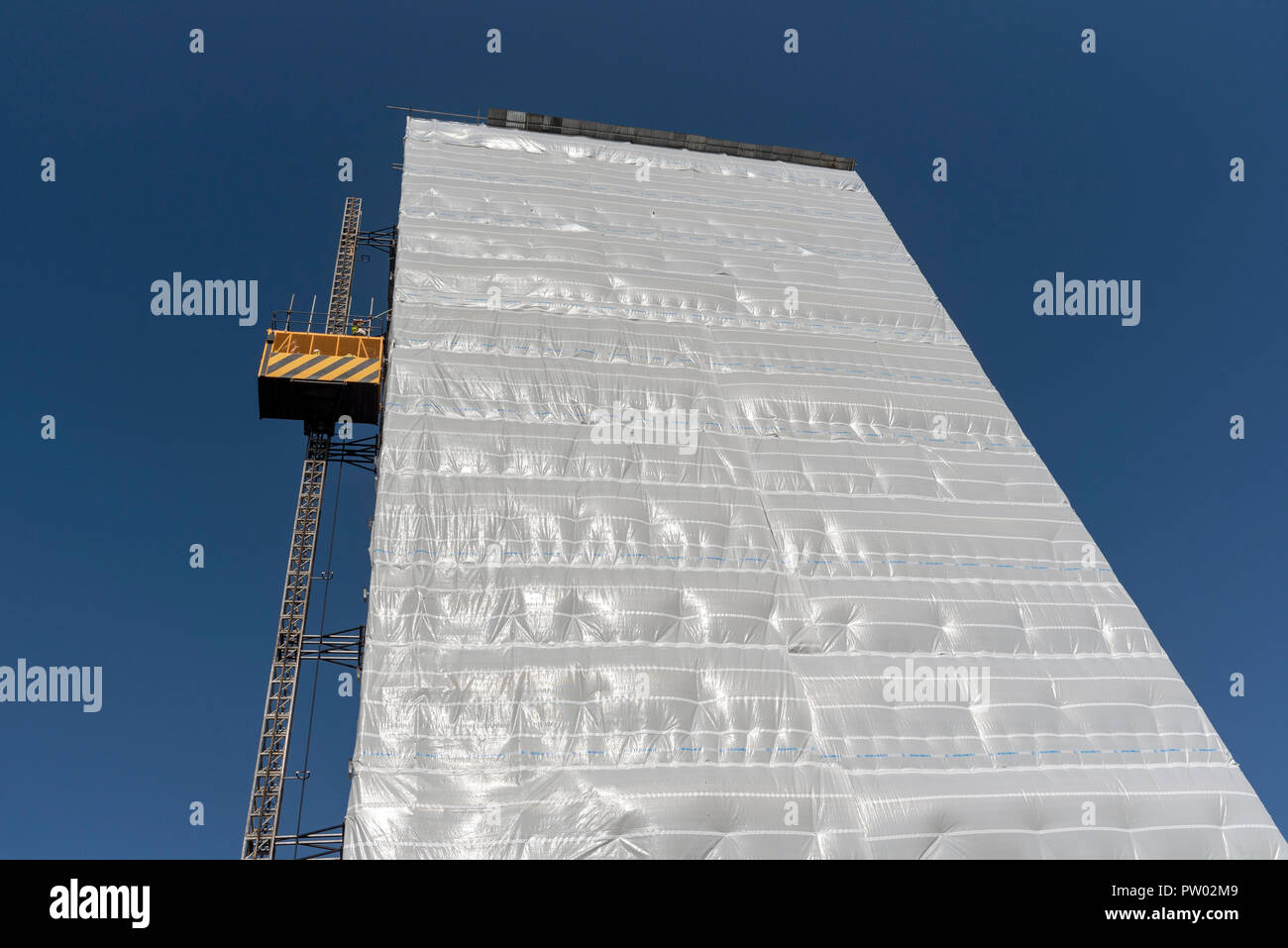 Highrise block of flats and apartments covered in plastic sheeting for weather protection whilst work is carried out on the building, Gosport, Hampshi Stock Photo