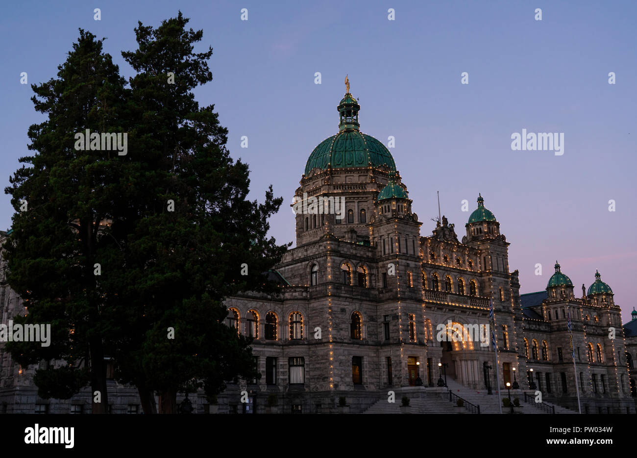 The British Columbia Parliament buildings in Victoria, seen with lights on at dawn. Stock Photo