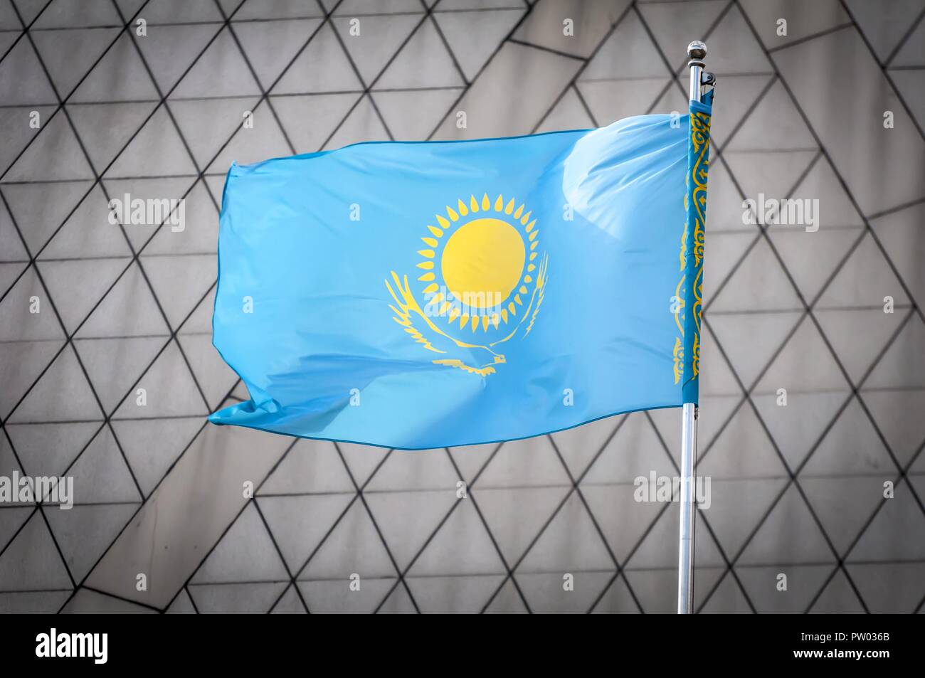 The official flag of the Republic of Kazakhstan waving in the sky against a  triangles background. Kazakh flag concept. Kazakhstan Independence Day Stock  Photo - Alamy