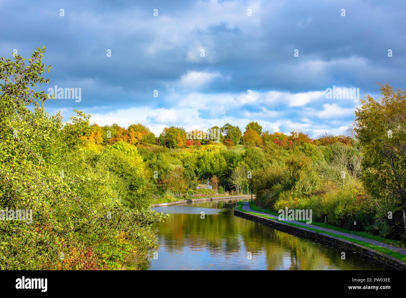 British landscape.Trent and Mersey canal in Stoke on Trent, Staffordshire,Uk on autumn day.Trees with leaves changing color reflections in water. Stock Photo
