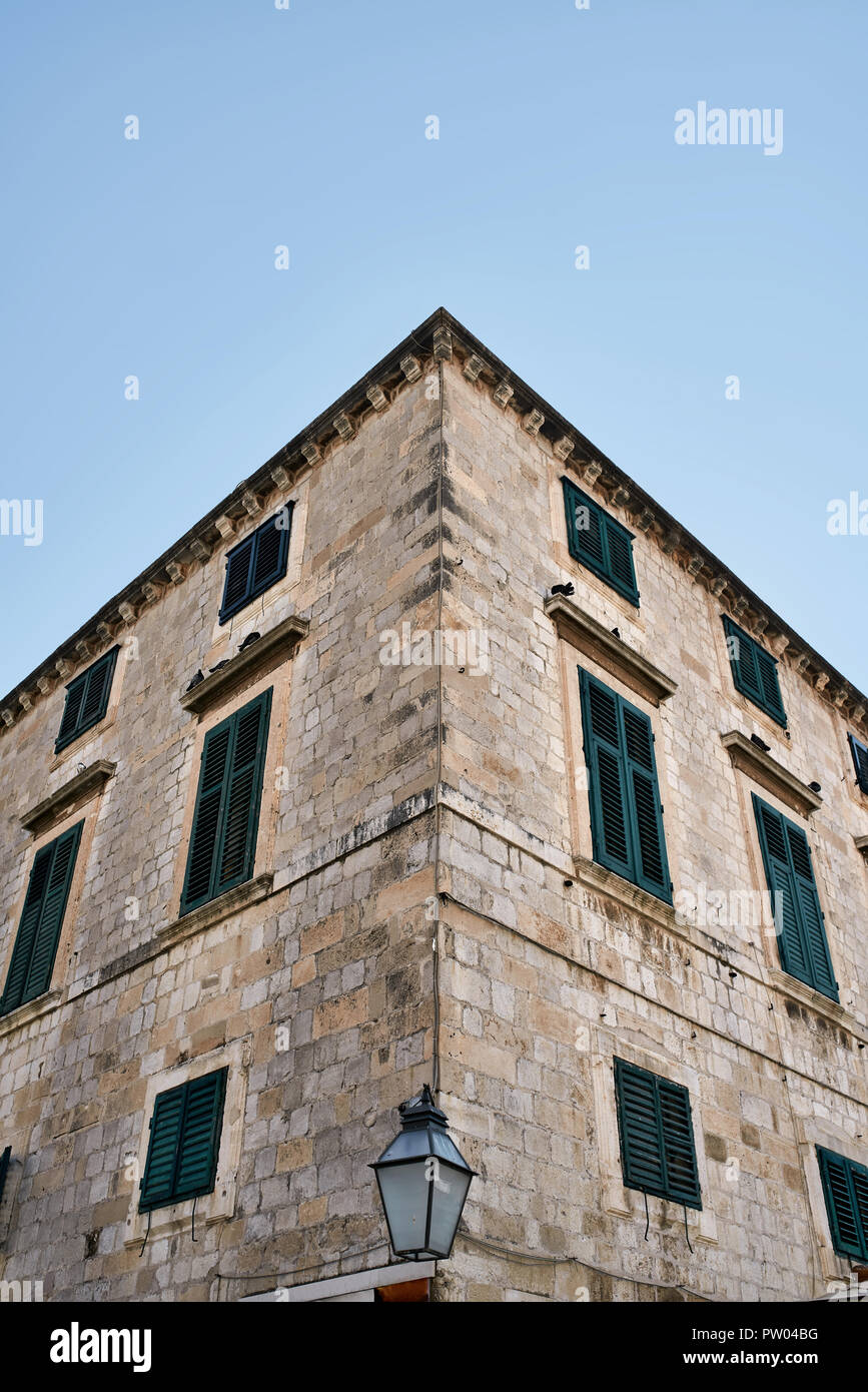 Facade of an old stone house with windows with wooden turquoise ...