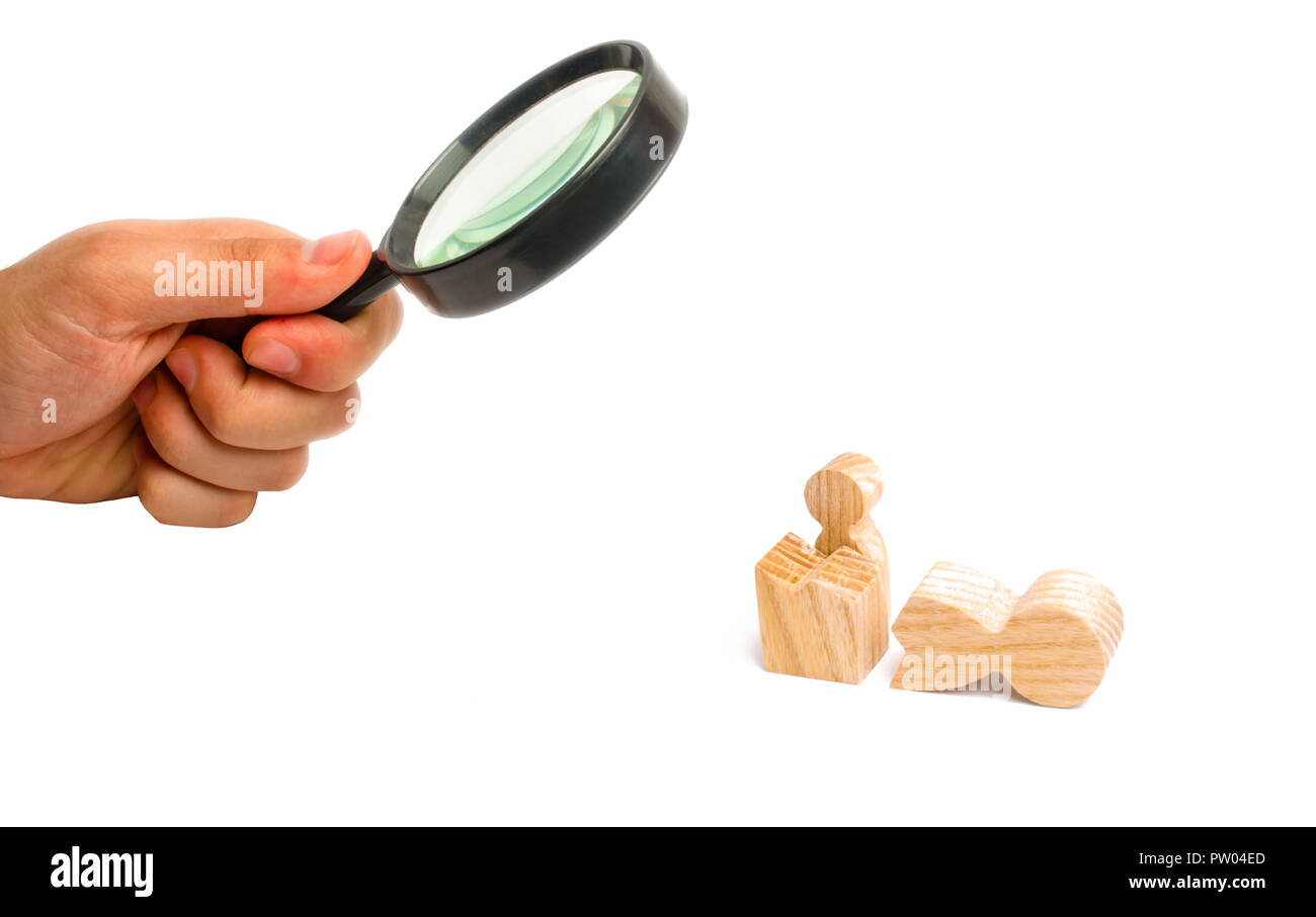 Magnifying glass is looking at a small figure of a man looks out of the remains of a large figure. a way out of the comfort zone. Reincarnation into a Stock Photo