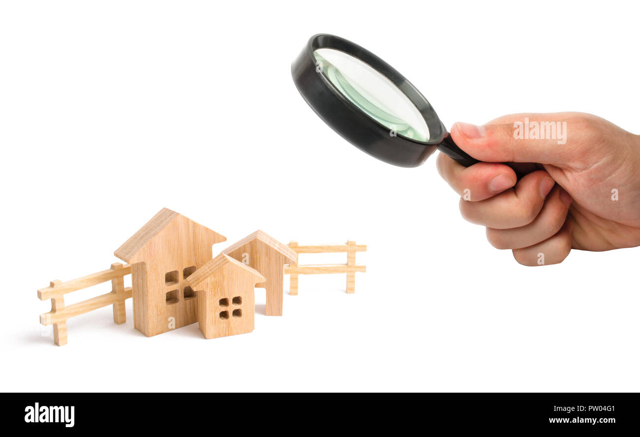 Magnifying glass is looking at the houses. City, settlement. Minimalism. for presentations. real estate market. Three houses on a white background and Stock Photo