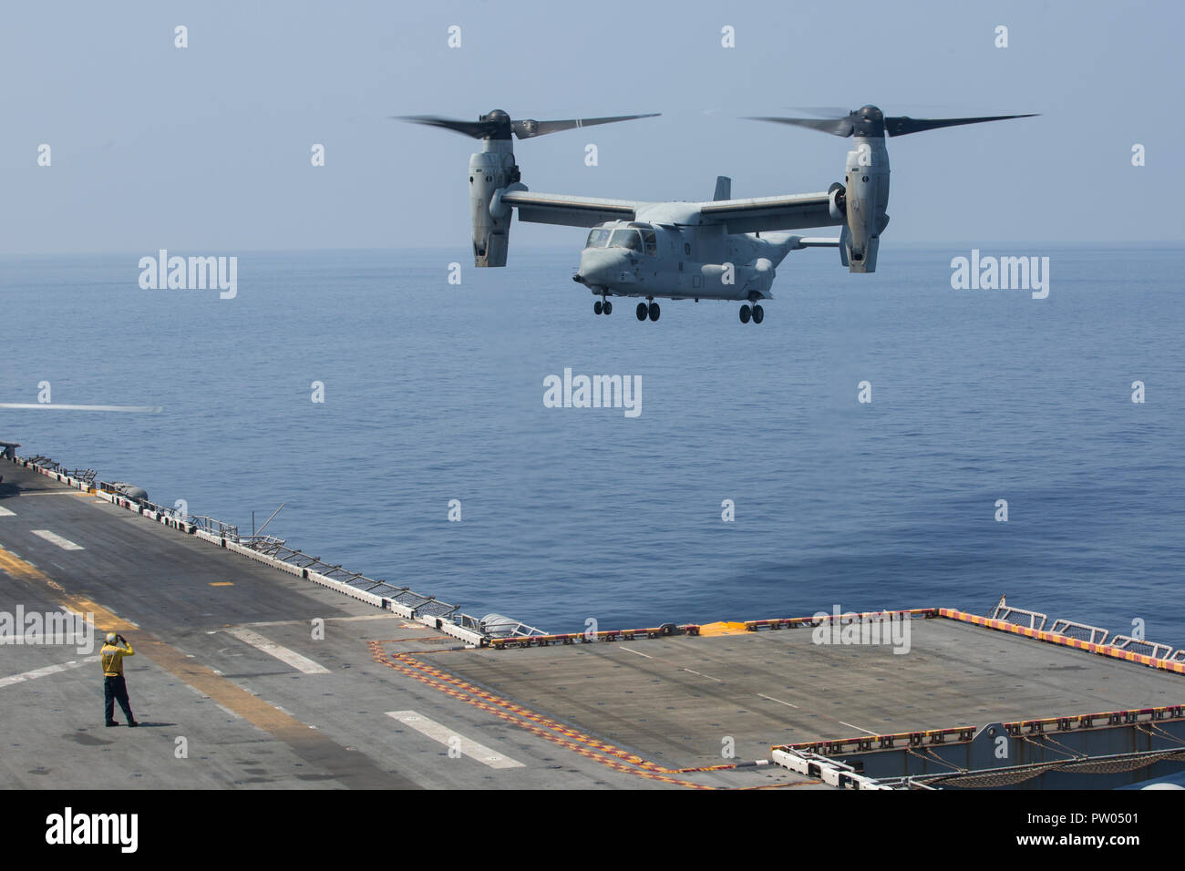 An MV-22B Osprey tiltrotor aircraft, belonging to Marine Medium Tiltrotor Squadron 262 (Reinforced), prepares to land on the flight deck of the amphibious assault ship USS Wasp (LHD 1), underway in the South China Sea, Oct. 11, 2018. Combat cargo Marines with the 31st Marine Expeditionary Unit off loaded the MV-22Bs, which brought back Marines and gear from exercise KAMANDAG 2. KAMANDAG 2 is a multinational exercise, including; the Republic of the Philippines, Japan, and the United States. The 31st MEU, the Marine Corps’ only continuously forward-deployed MEU, provides a flexible force ready t Stock Photo