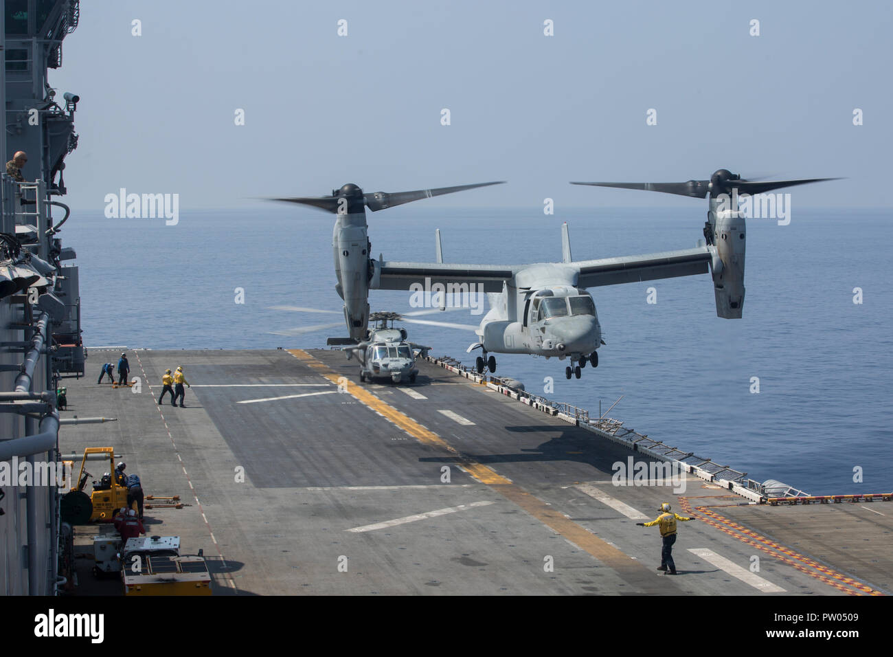 An MV-22B Osprey tiltrotor aircraft, belonging to Marine Medium Tiltrotor Squadron 262 (Reinforced), lands on the flight deck of the amphibious assault ship USS Wasp (LHD 1), underway in the South China Sea, Oct. 11, 2018. Combat cargo Marines with the 31st Marine Expeditionary Unit off loaded the MV-22B’s, which brought back Marines and gear from exercise KAMANDAG 2. KAMANDAG 2 is a multinational exercise, including; the Republic of the Philippines, Japan, and the United States. The 31st MEU, the Marine Corps’ only continuously forward-deployed MEU, provides a flexible force ready to perform  Stock Photo