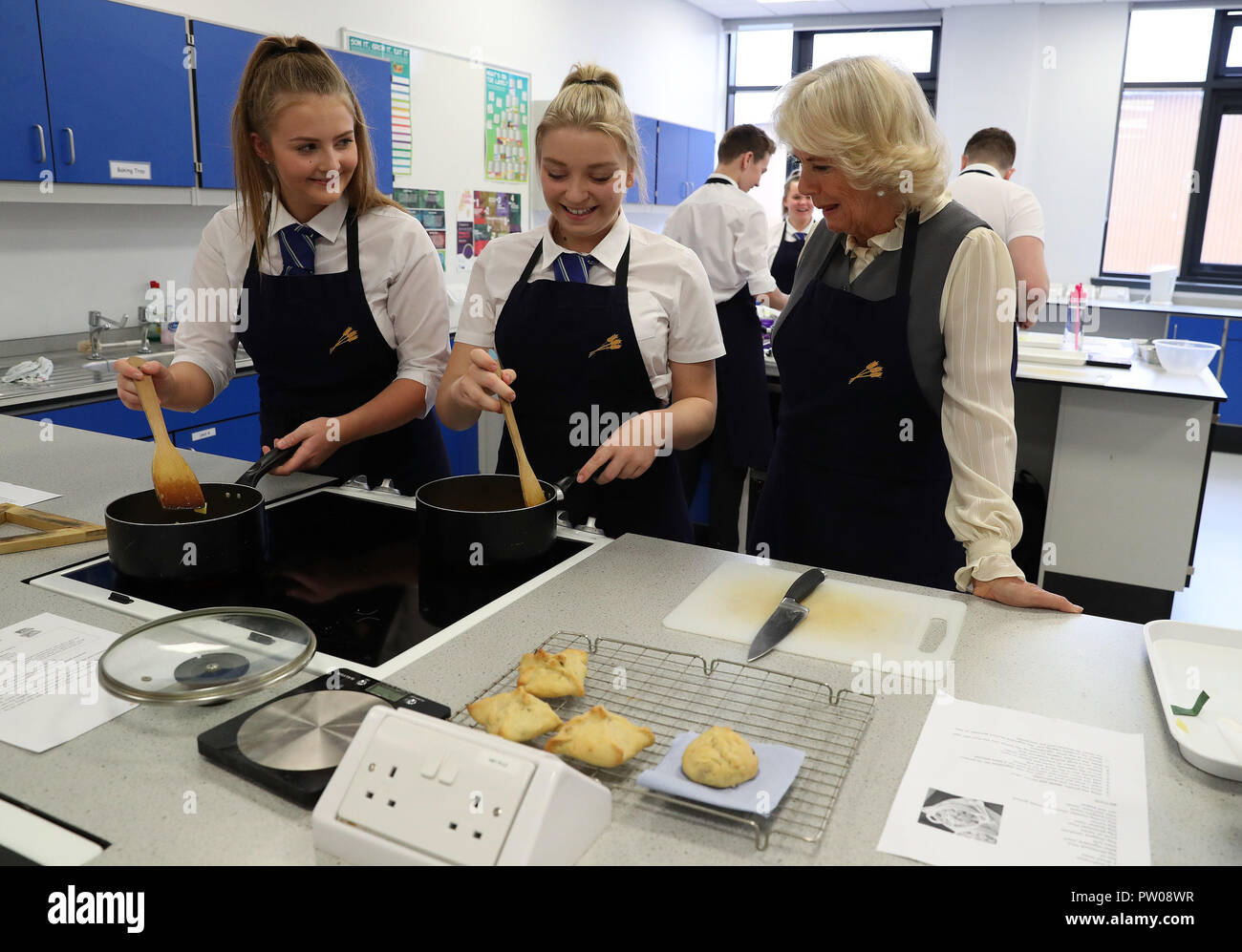 The Duchess of Cornwall, known as the Duchess of Rothesay in Scotland with Alford Academy pupils Emily Robertson(L) and Zoe Anderson as she joins them in a cookery class at Alford Community Campus in Aberdeenshire, Scotland. Stock Photo