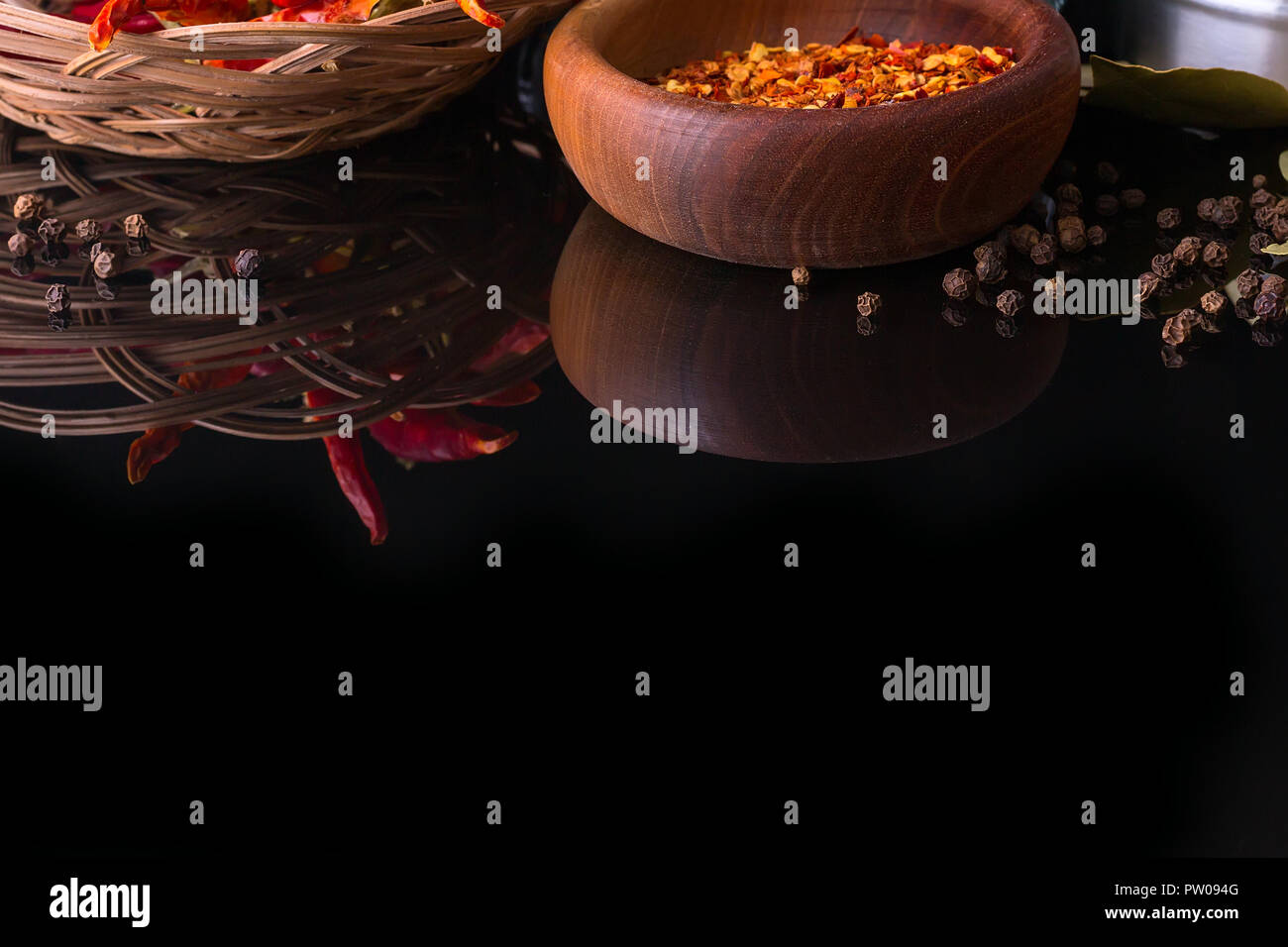 Spices and herbs, red chili peppers, black peppercorn and wooden bowl