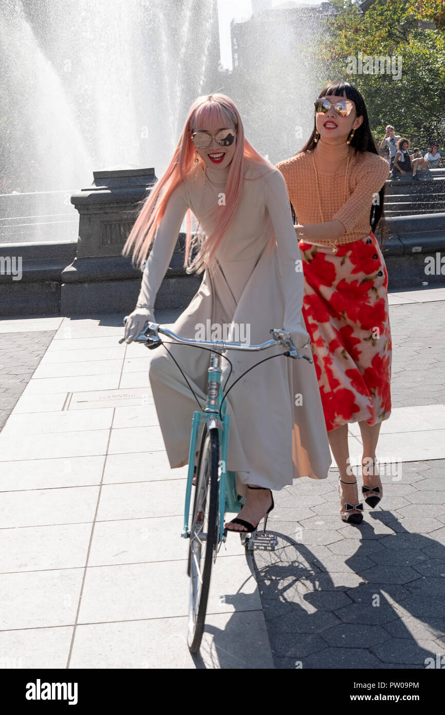 Two beautiful slender Japanese models being photographed on a fashion shoot in Washington Square Park in Greenwich Village, New York City. Stock Photo