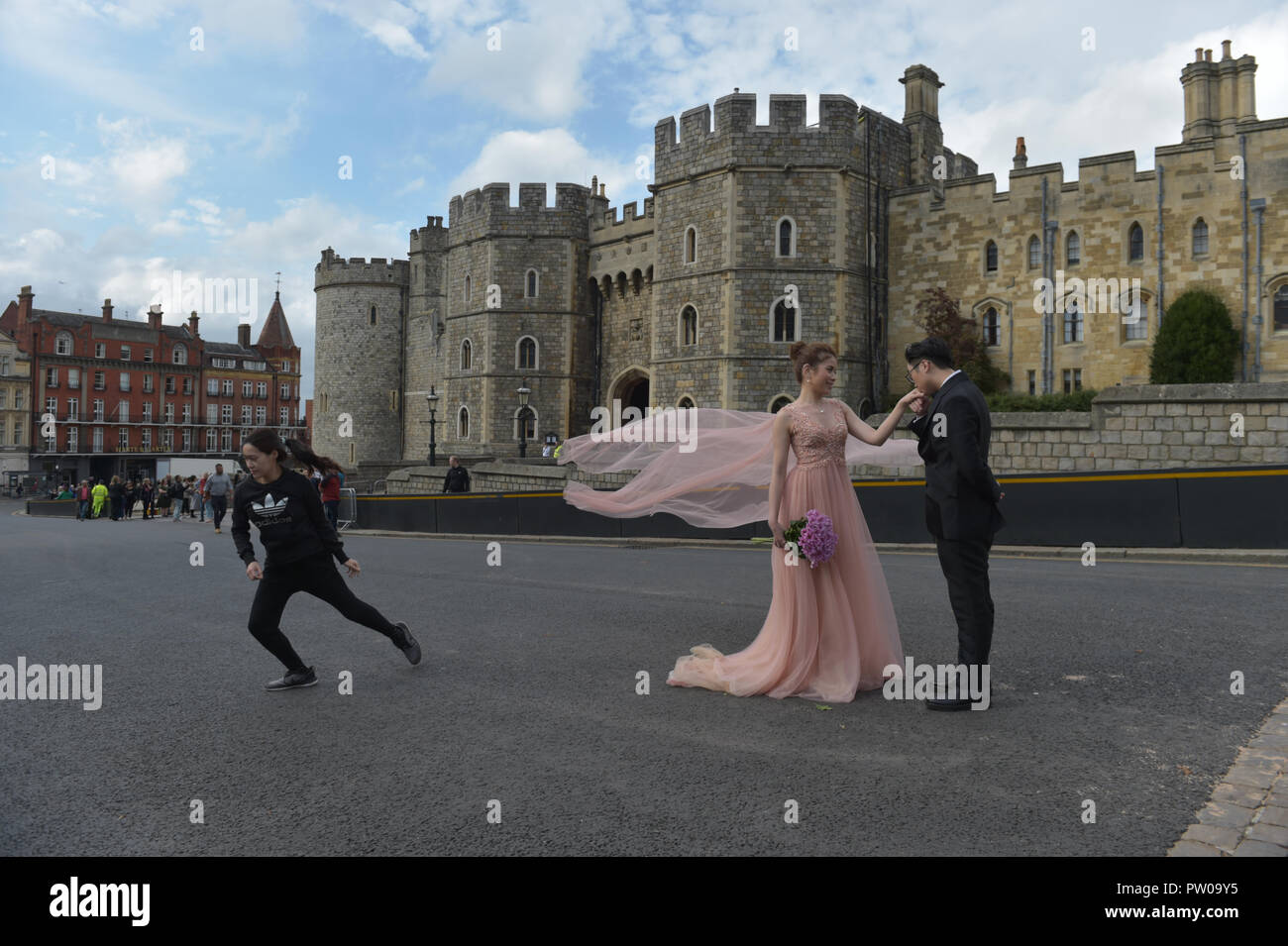 A couple from Hong Kong (names not supplied) have their wedding pictures taken before their ceremony outside Windsor Castle, ahead of the wedding of Princess Eugenie to Jack Brooksbank, which is taking place tomorrow in St George's Chapel. Stock Photo