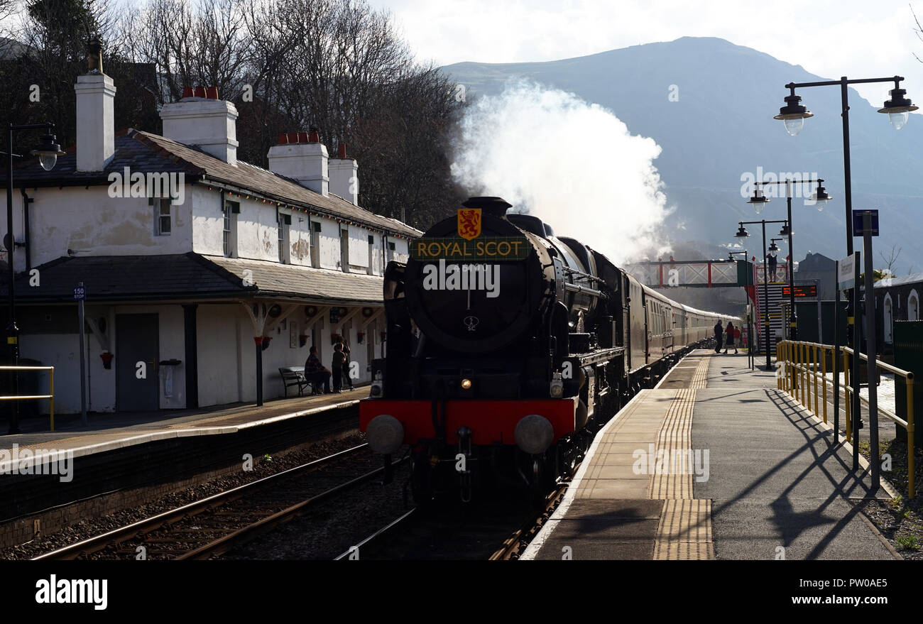 The Royal Scot Steam Train passing through Penmaenmawr Train Station, at around 60 mph, quite a sight! Image taken in April 2018. Stock Photo