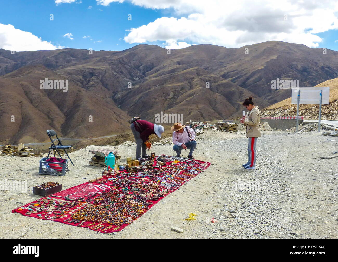 Vendor selling Tibetan stones, beads and souvenirs along the Kampala Pass serving customers on the way to Yamdrok Lake. Stock Photo
