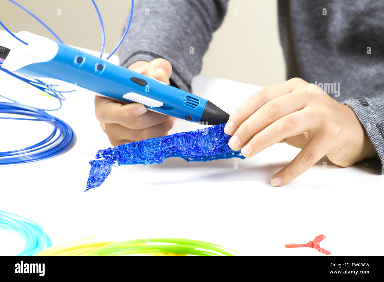 Kid's hands creating with 3d printing pen Stock Photo - Alamy