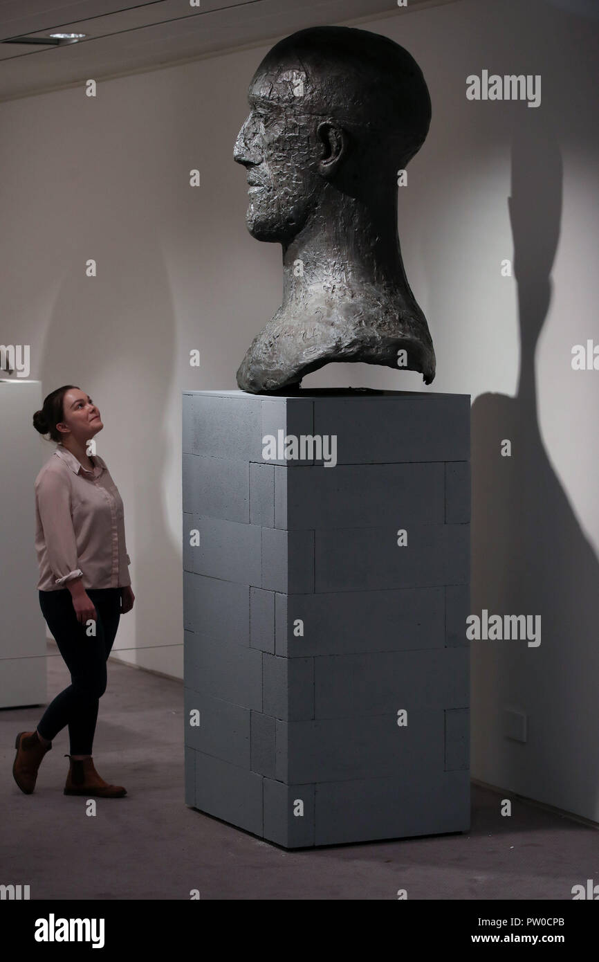 A visitor looks at a Tribute Head on display at the Elisabeth Frink Humans and Other Animals exhibition preview at the Sainsbury Centre for Visual Arts in Norwich, Norfolk. Stock Photo