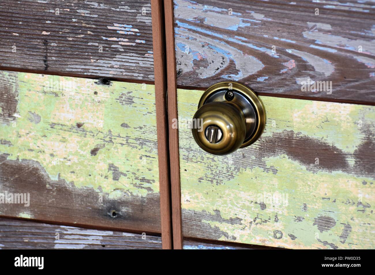 Wall which is all reclaimed wood at door jam with locking handle