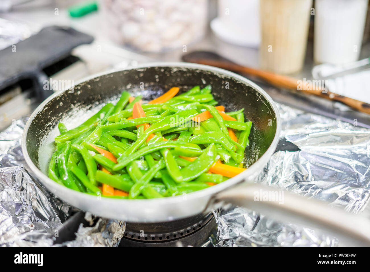 Green beans and carrot fried together on silver pan in the restaurant