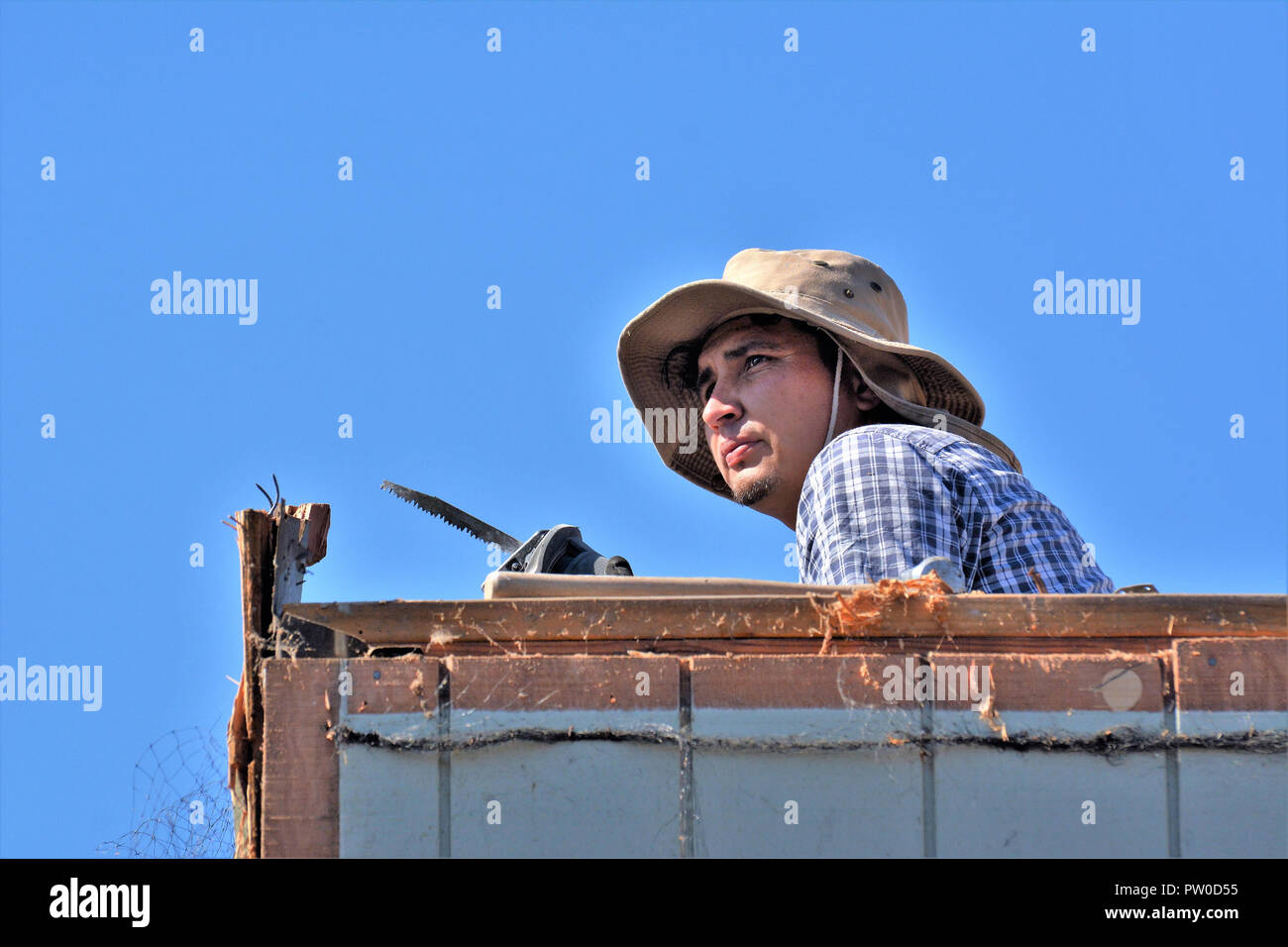 Latin labor knocking down a home for addition upstairs Stock Photo