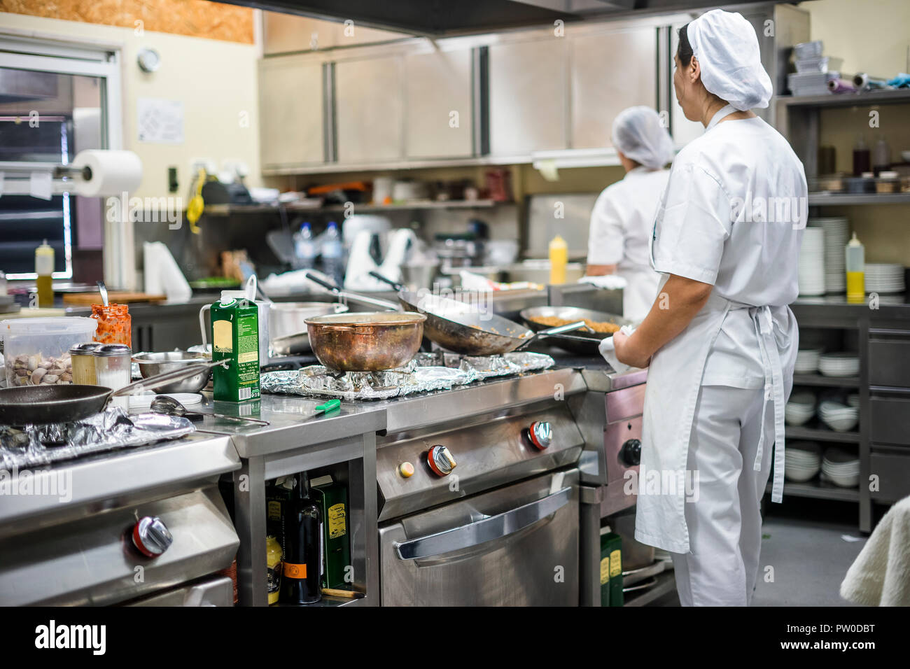 Kitchen staff busy with preparing food during lunch time in the restaurant Stock Photo