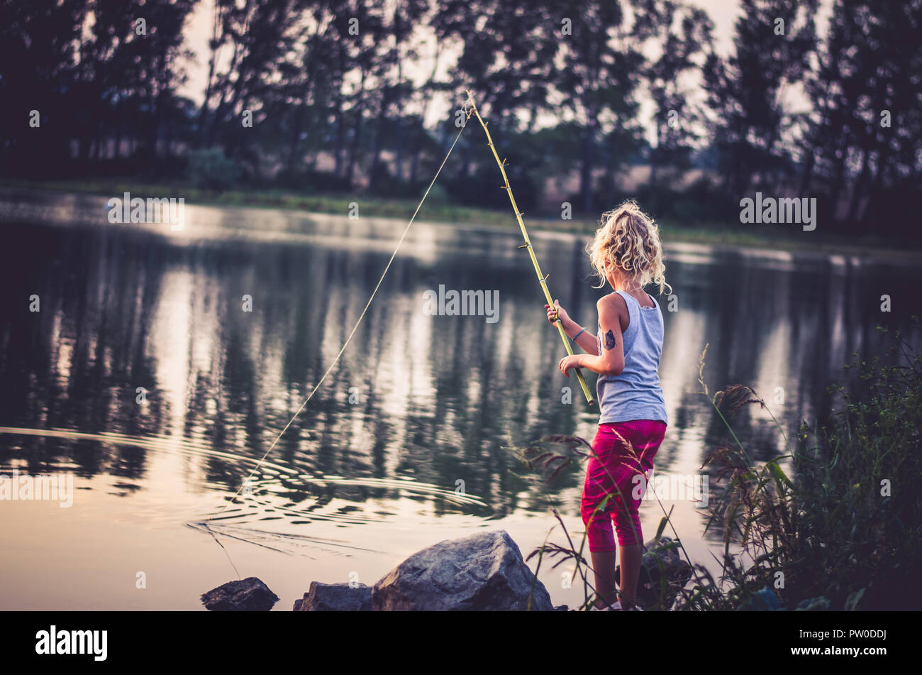 adorable little girl fishing with home made fishing rod at the