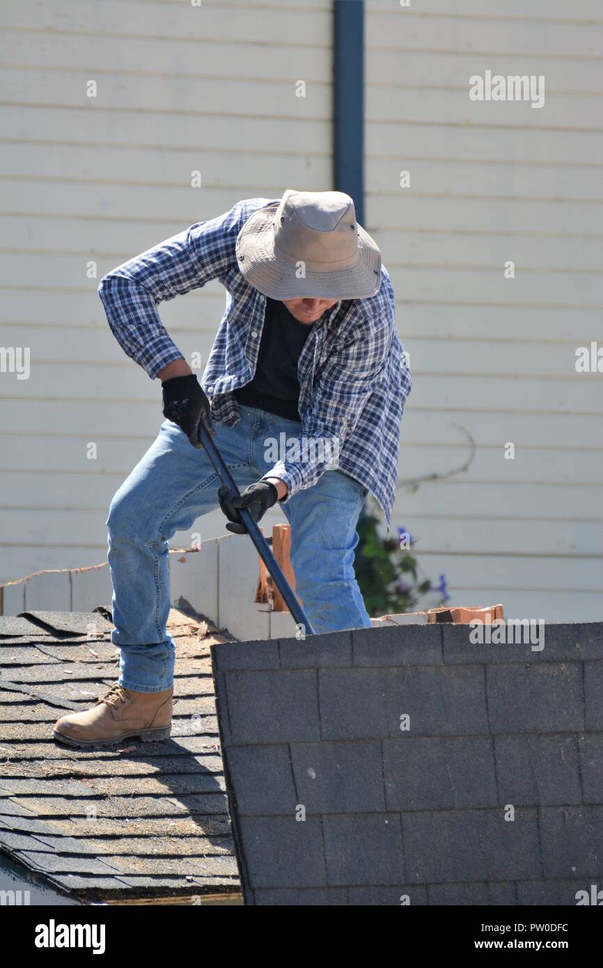 Latin labor knocking down a home for addition upstairs Stock Photo