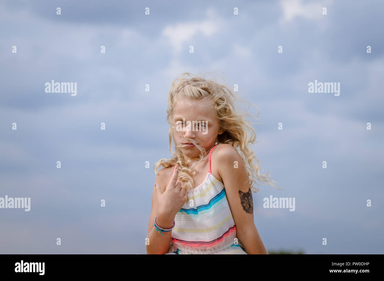 adorable little girl with blond hair portrait and blue sky Stock Photo