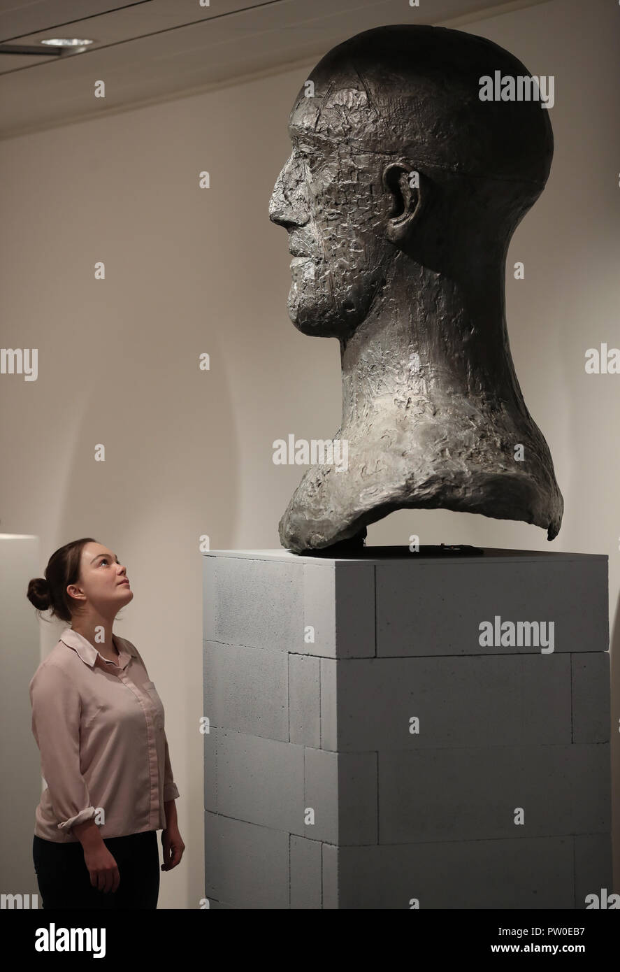 A visitor looks at a Tribute Head on display at the Elisabeth Frink Humans and Other Animals exhibition preview at the Sainsbury Centre for Visual Arts in Norwich, Norfolk. PRESS ASSOCIATION Photo. Picture date: Thursday October 11, 2018. The exhibition will provide new perspectives and examine her radical and bohemian beginnings in 1950s London, reappraising one of the most important British sculptors of the twentieth century. Photo credit should read: Chris Radburn/PA Wire Stock Photo