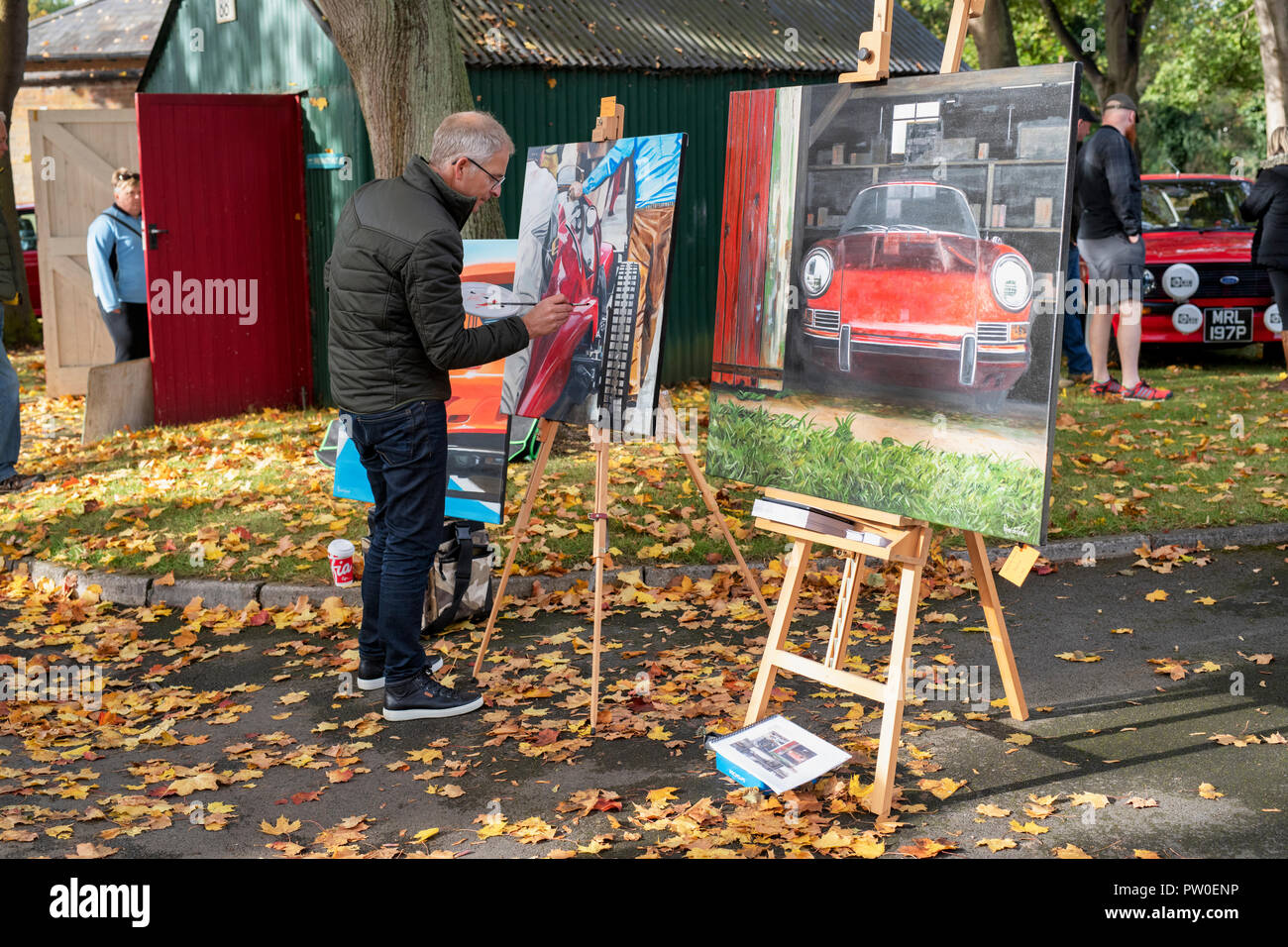 Artist painting car paintings at Bicester Heritage centre. Bicester, Oxfordshire, England Stock Photo