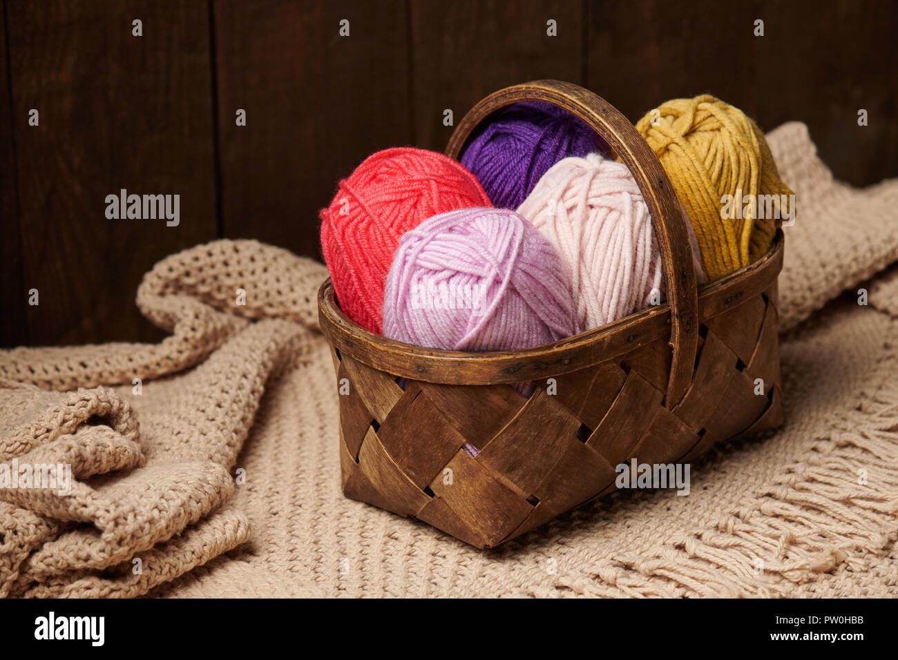 colorful wool threads for knitting in basket, wooden background Stock ...