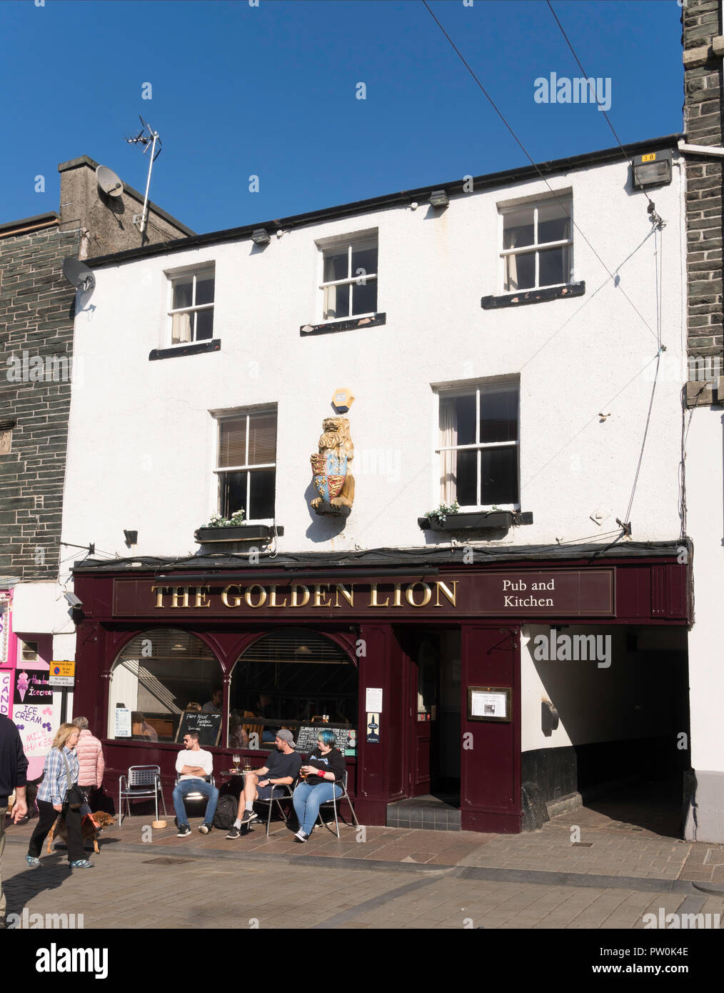 People sat outside The Golden Lion pub in Keswick, Cumbria, England, UK Stock Photo