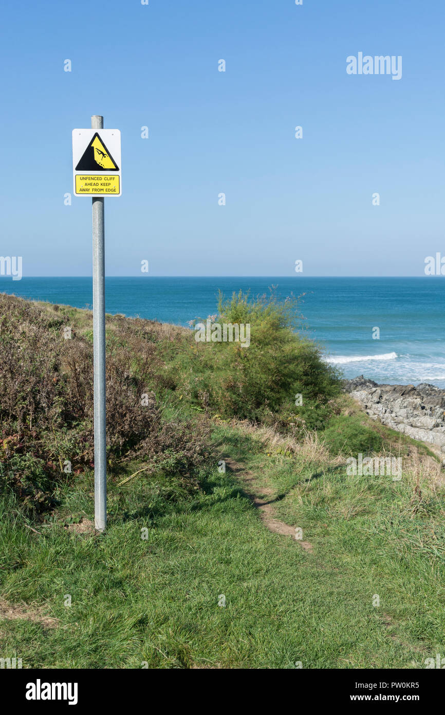 Cliff danger warning sign - with man falling over cliff, cliff edge. Keep away from the edge concept, falling off, falling man pictogram. Stock Photo