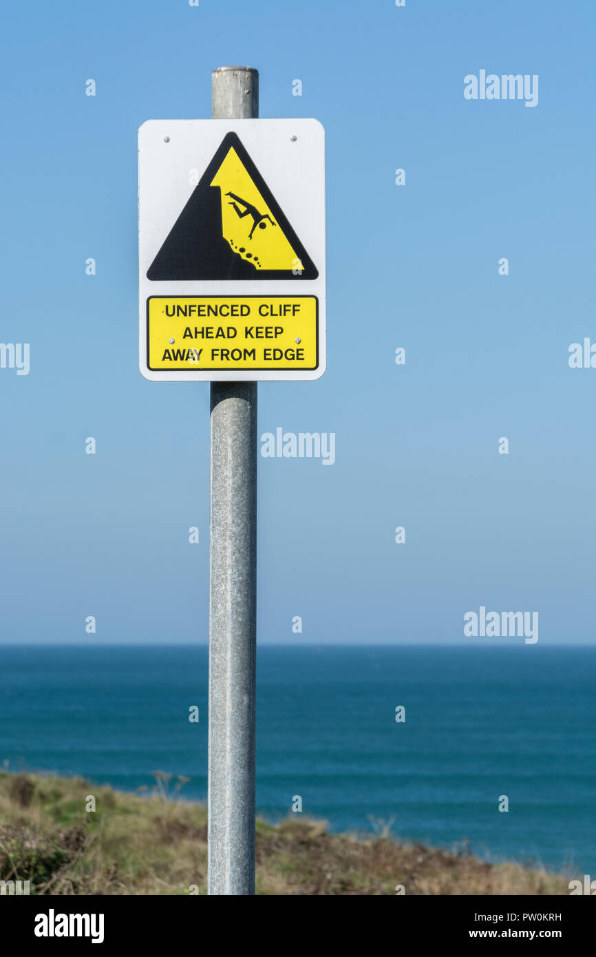 Cliff danger warning sign - with man falling over cliff, cliff edge. Keep away from the edge concept, falling off, falling man pictogram. Stock Photo