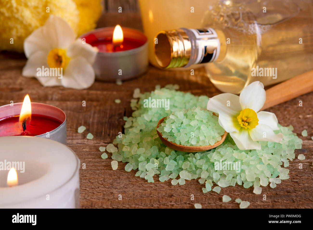 Spa still life with bath salt candles and flowers on wodden table. Body beauty and care concept. Stock Photo