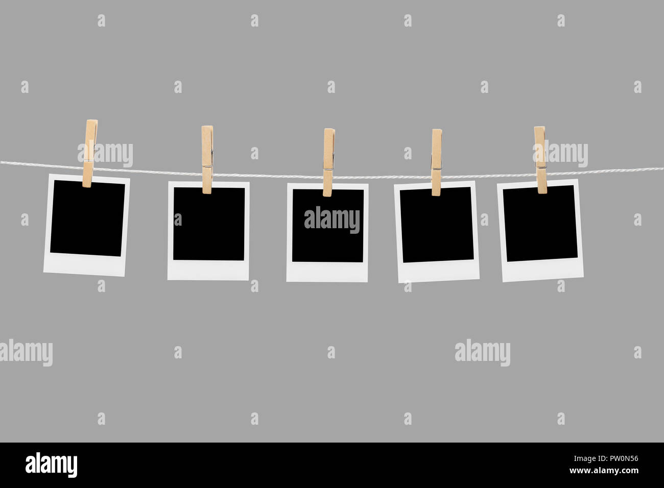 Old picture frame hanging on clothesline on background. Stock Photo