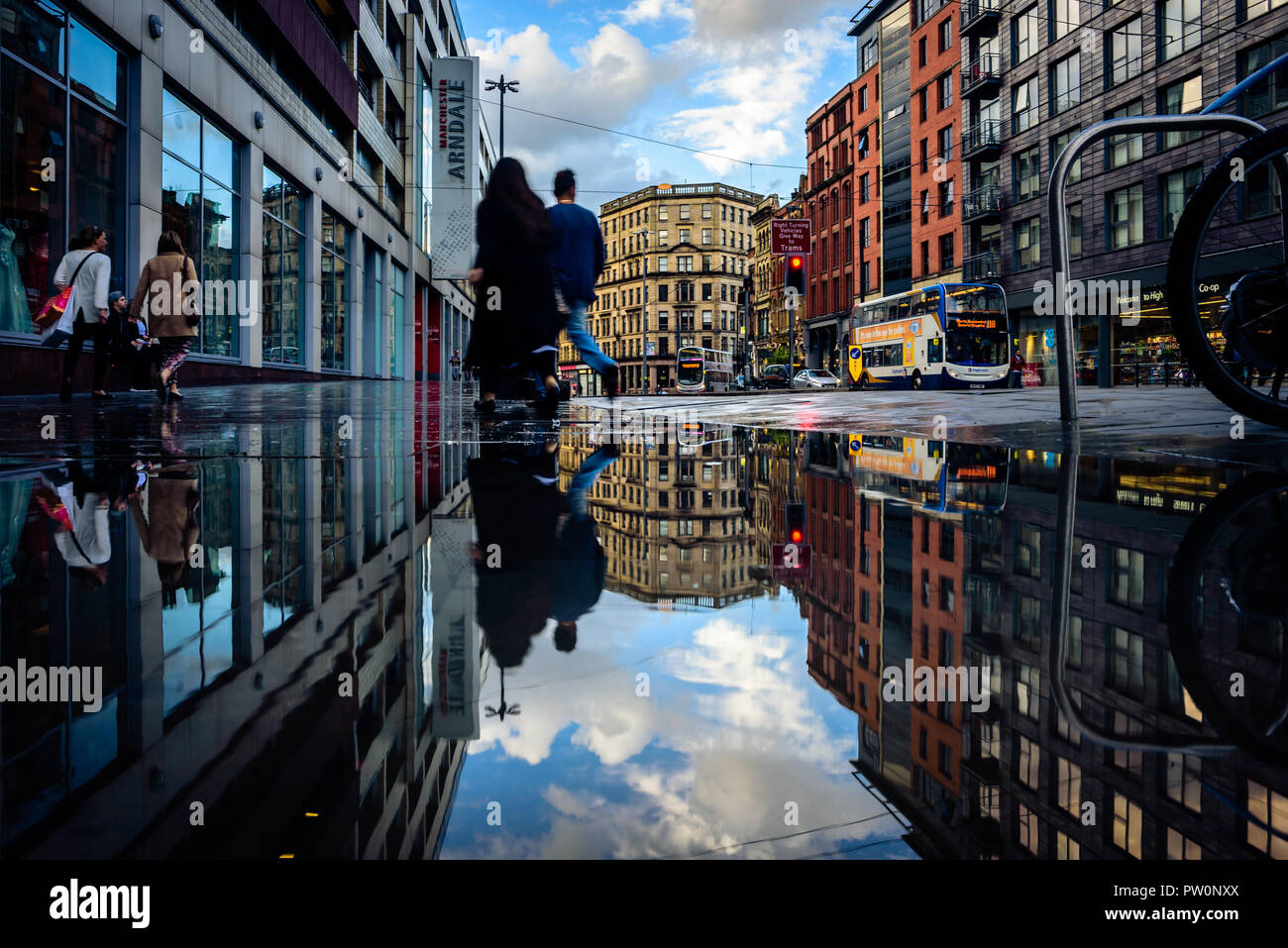 Shoppers going about their business in the city centre. Interestingly symmetrical image of Manchester City Centre. Stock Photo